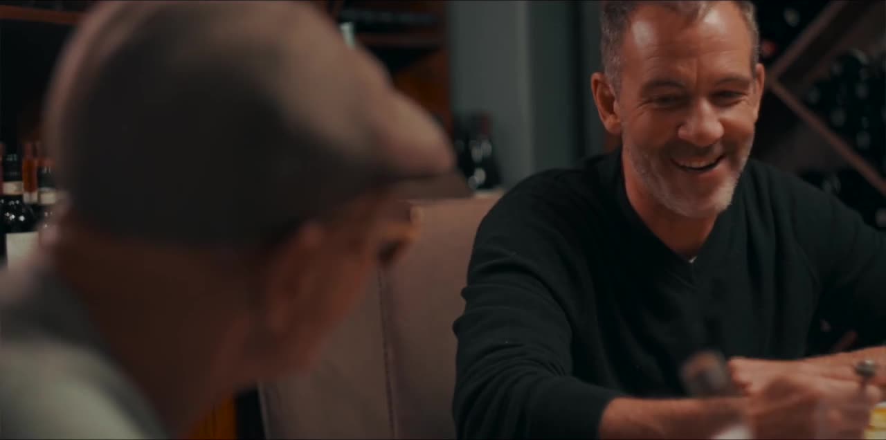 Callen smiling across a table in the Black Mass scene